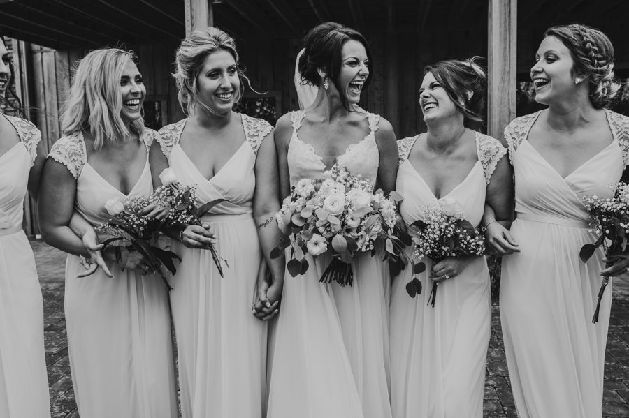 Candid black and white capture of Cortni walking with her bridesmaids