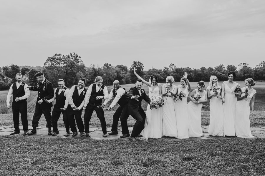 Black and white candid capture of wedding party dancing