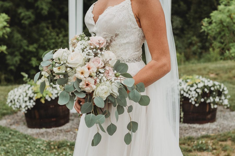 Bridal bouquet of white and pale pink roses and baby's breath with eucalyptus