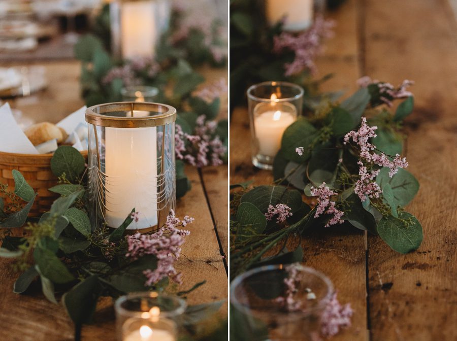 Cream colored candles in a glass and gold jar on a wood table