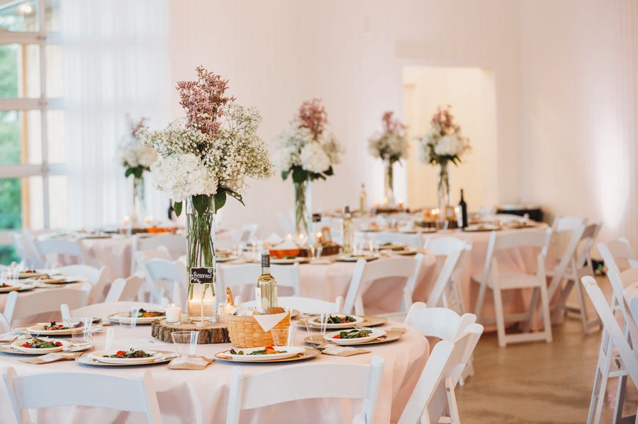 White viburnum and baby's breath centerpieces on blush linens at Rusty River Barn
