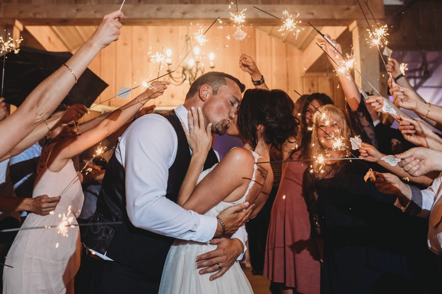 Cortni and Darren sharing a kiss under the sparklers at the end of the night at Rusty River Barn