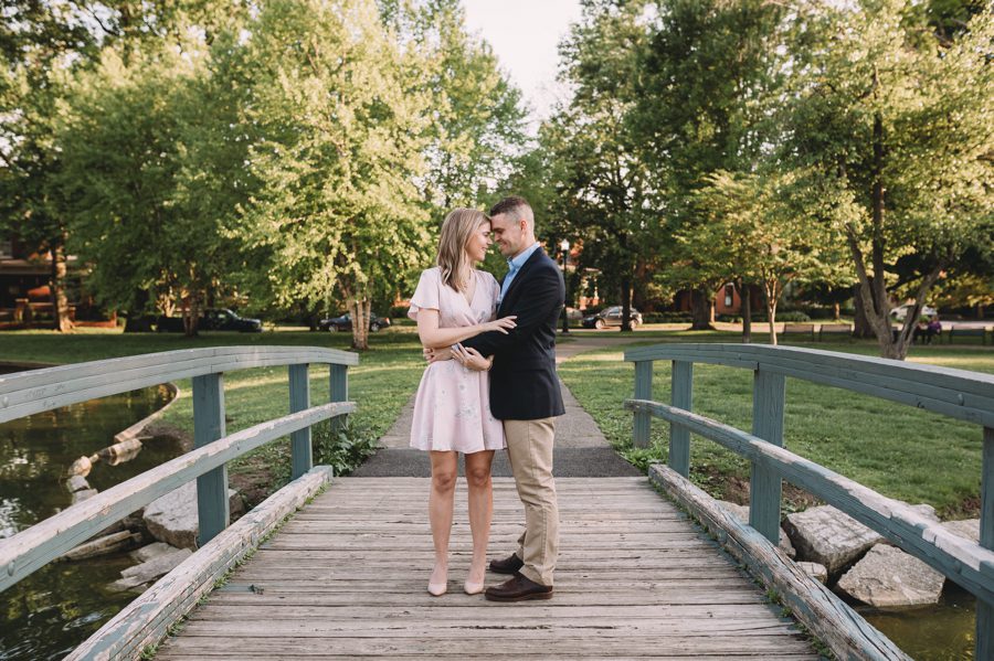 Schiller Park Engagement Photos of engaged couple with foreheads together on bridge